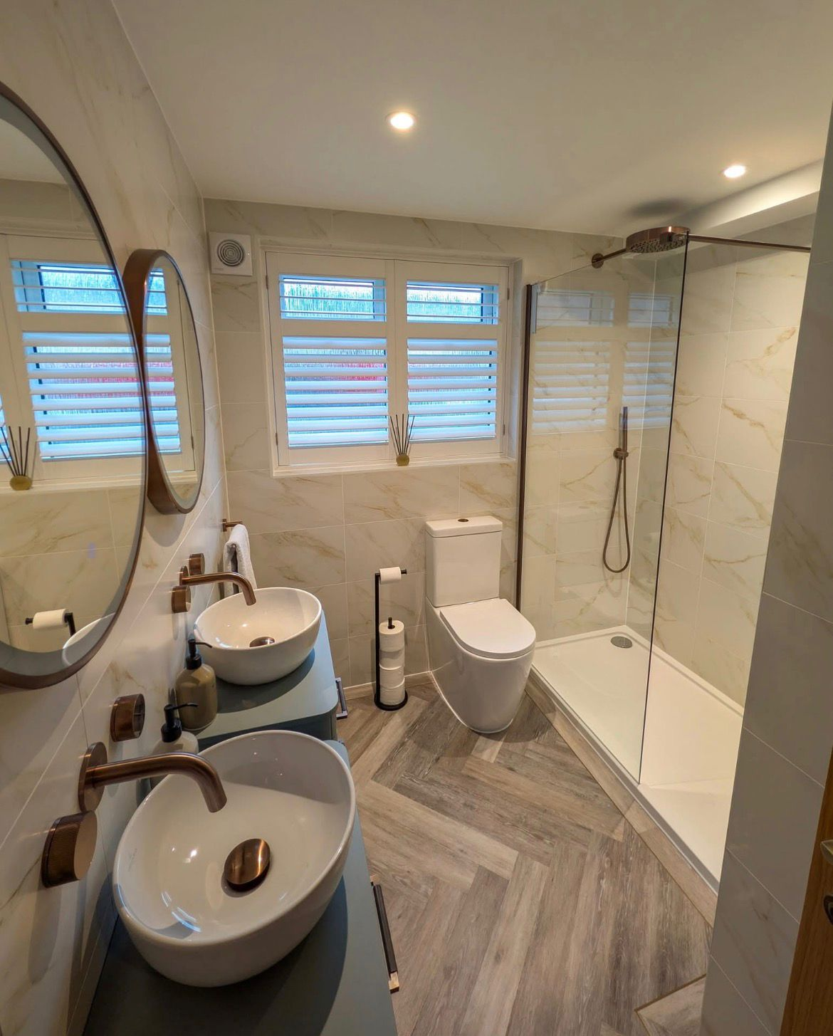 Luxury en-suite with marble tiles, brass fittings, double vessel sinks and walk-in shower — Avanza project, Essex